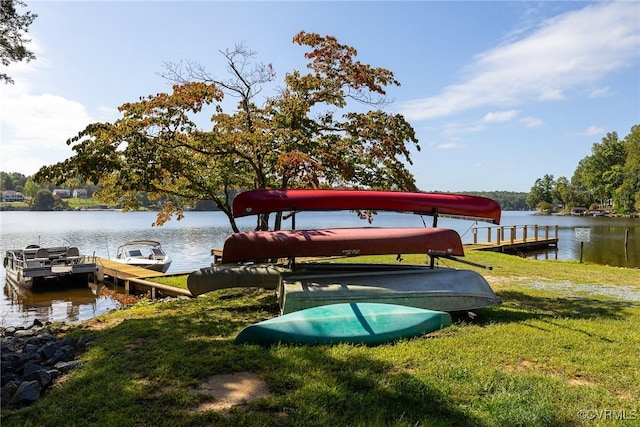 view of dock featuring a lawn and a water view