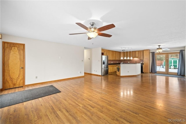 unfurnished living room featuring ceiling fan and light hardwood / wood-style floors