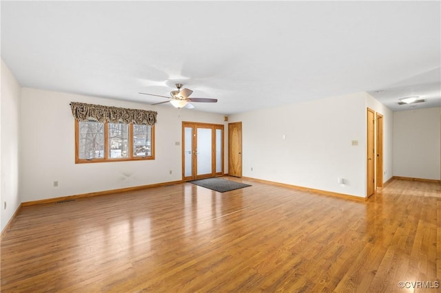 unfurnished living room featuring french doors, ceiling fan, and light hardwood / wood-style floors