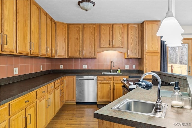 kitchen featuring tasteful backsplash, sink, decorative light fixtures, and dishwasher