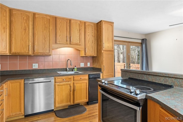 kitchen with french doors, sink, stainless steel appliances, light hardwood / wood-style floors, and decorative backsplash