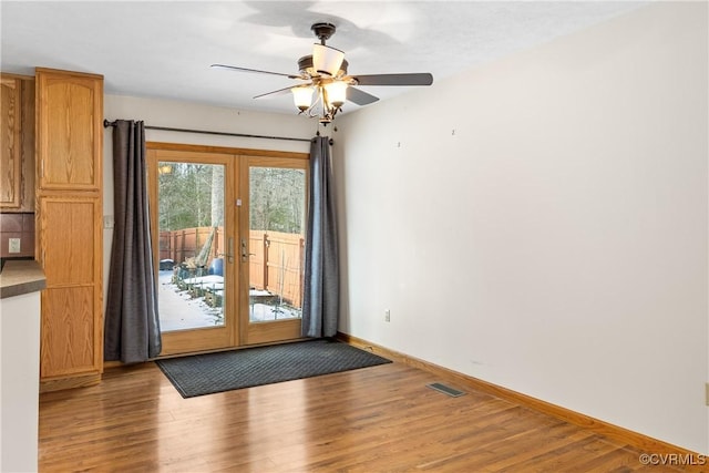 doorway with wood-type flooring, ceiling fan, and french doors