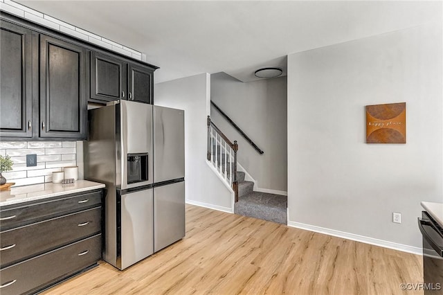 kitchen featuring stainless steel refrigerator with ice dispenser, tasteful backsplash, and light wood-type flooring