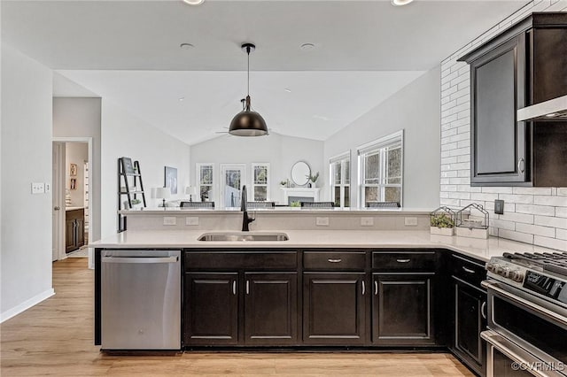 kitchen featuring pendant lighting, appliances with stainless steel finishes, sink, light wood-type flooring, and tasteful backsplash