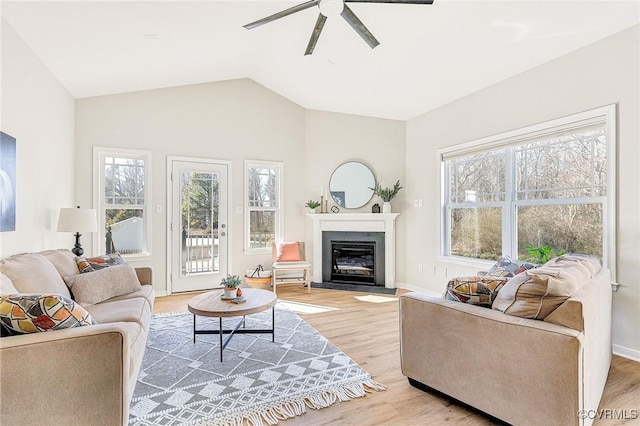 living room with ceiling fan, light hardwood / wood-style floors, and lofted ceiling