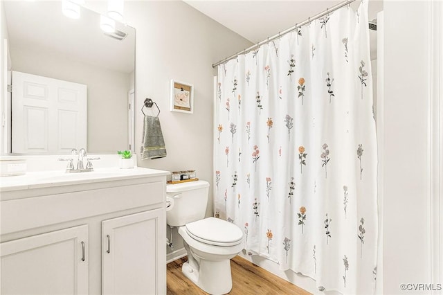 bathroom featuring a shower with curtain, hardwood / wood-style flooring, toilet, and vanity