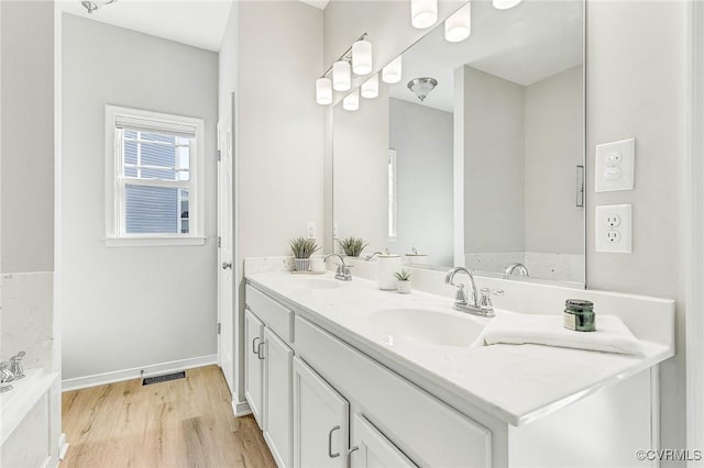 bathroom featuring hardwood / wood-style floors, a bathtub, and vanity