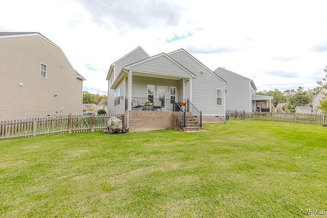 back of property with a porch and a yard