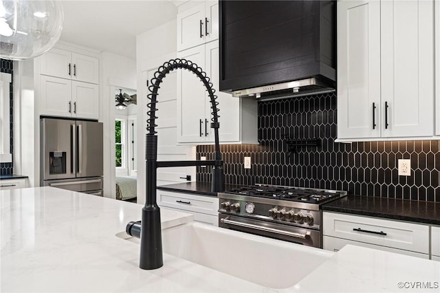 kitchen with white cabinets, decorative light fixtures, premium range hood, stainless steel appliances, and decorative backsplash