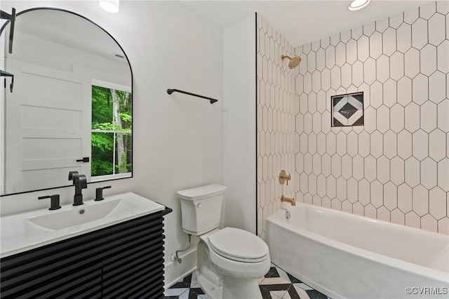 bathroom featuring baseboards, toilet, tub / shower combination, vanity, and tile patterned flooring