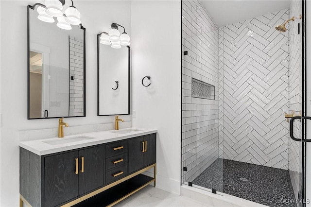 bathroom featuring a shower stall, double vanity, marble finish floor, and a sink