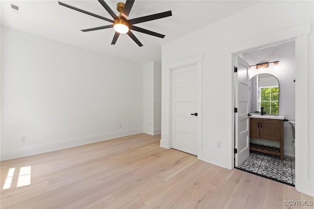 bedroom featuring visible vents, ensuite bathroom, light wood-style flooring, and baseboards