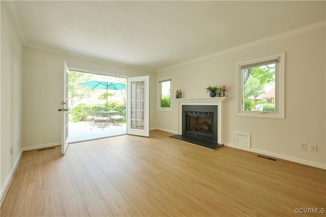 unfurnished living room featuring crown molding, plenty of natural light, and light hardwood / wood-style floors