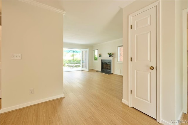 unfurnished living room with ornamental molding and light hardwood / wood-style floors