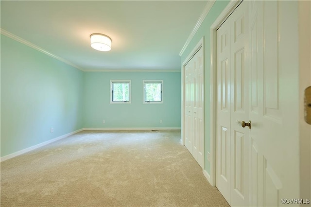 unfurnished bedroom with two closets, ornamental molding, and light colored carpet