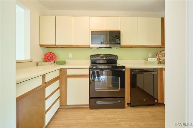 kitchen with light wood-type flooring and black appliances