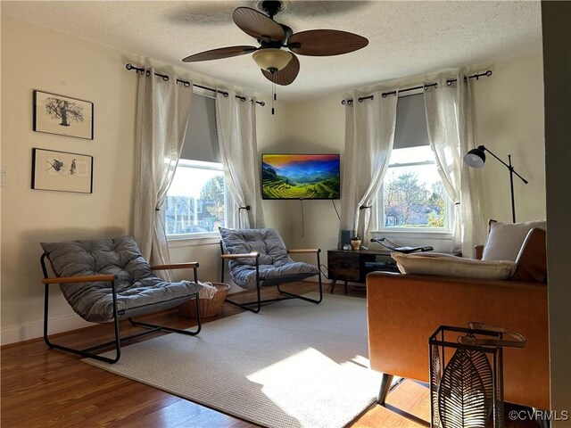 sitting room with a textured ceiling, ceiling fan, and hardwood / wood-style flooring