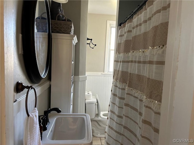 bathroom featuring toilet, tile patterned flooring, and sink