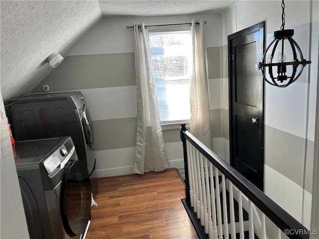 laundry room with a healthy amount of sunlight, wood-type flooring, separate washer and dryer, and a textured ceiling