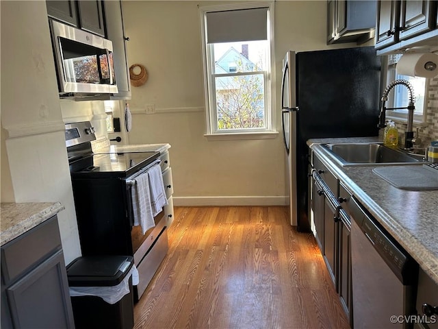 kitchen featuring sink, hardwood / wood-style floors, and appliances with stainless steel finishes