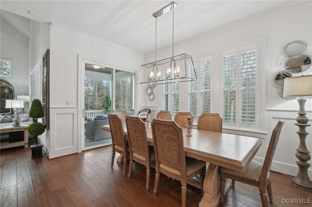 dining area with crown molding, dark wood-type flooring, and a notable chandelier