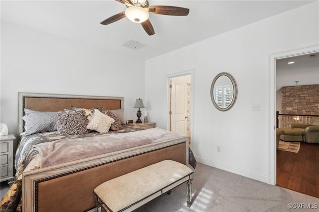 bedroom with ceiling fan, ensuite bathroom, and light colored carpet