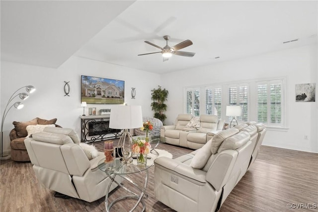 living room featuring dark wood-type flooring and ceiling fan