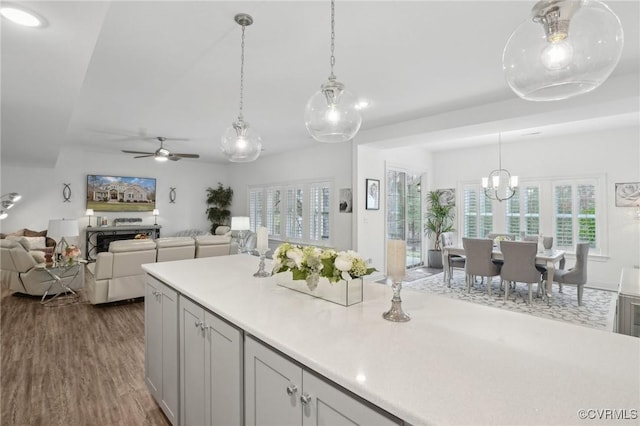 kitchen with hardwood / wood-style flooring, ceiling fan, and decorative light fixtures