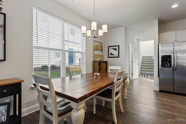 dining space featuring dark hardwood / wood-style floors and a chandelier