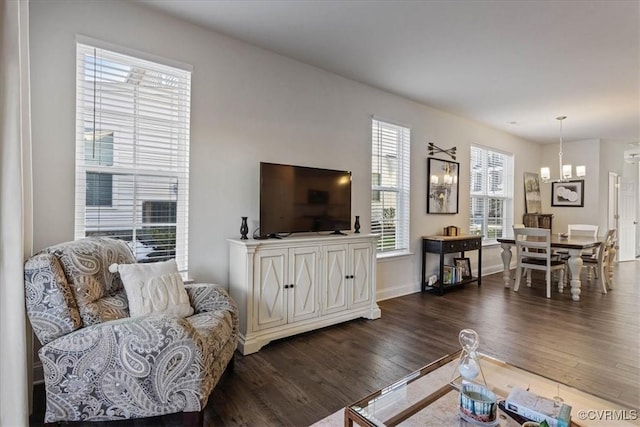 living room featuring dark wood-type flooring and a notable chandelier