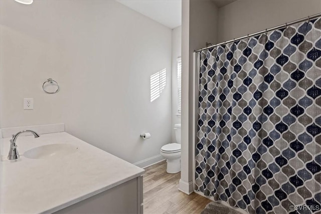 bathroom with toilet, hardwood / wood-style floors, and vanity