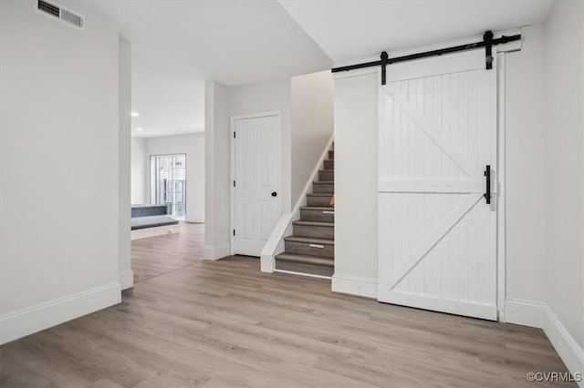 interior space with a barn door and light wood-type flooring