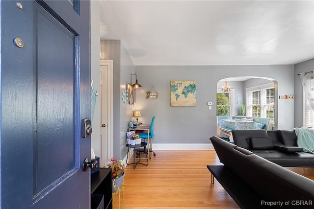 foyer entrance with an inviting chandelier and hardwood / wood-style flooring