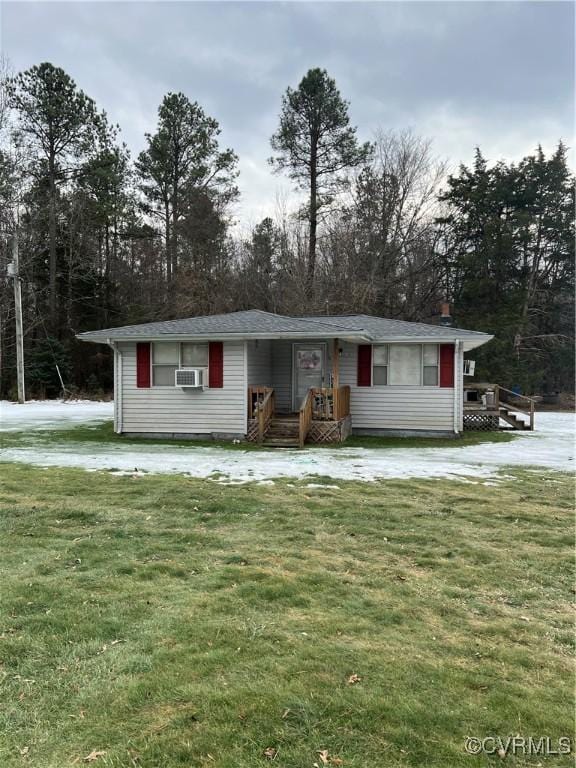 single story home with cooling unit and a front lawn