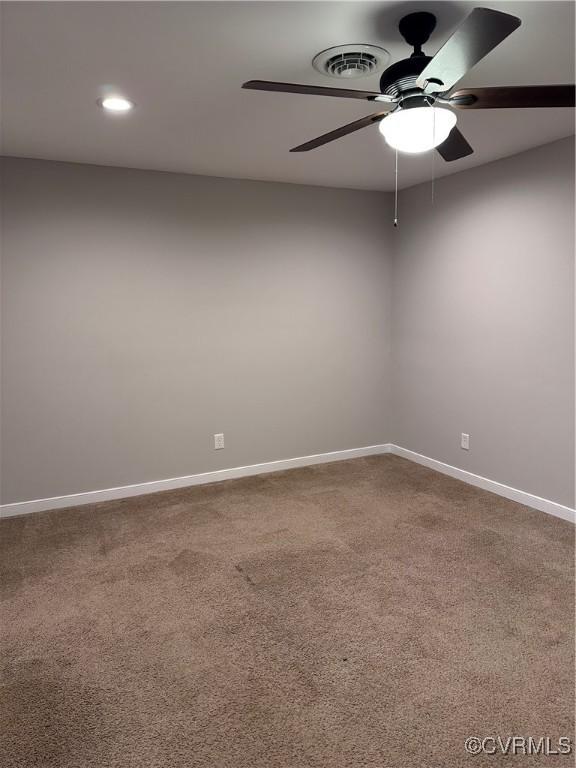 spare room featuring ceiling fan and carpet