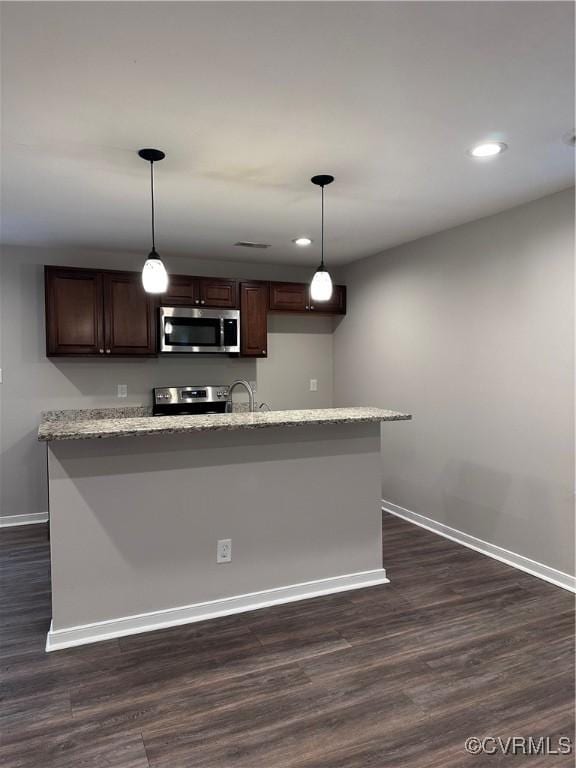 kitchen with stainless steel appliances, dark brown cabinets, dark hardwood / wood-style floors, and decorative light fixtures