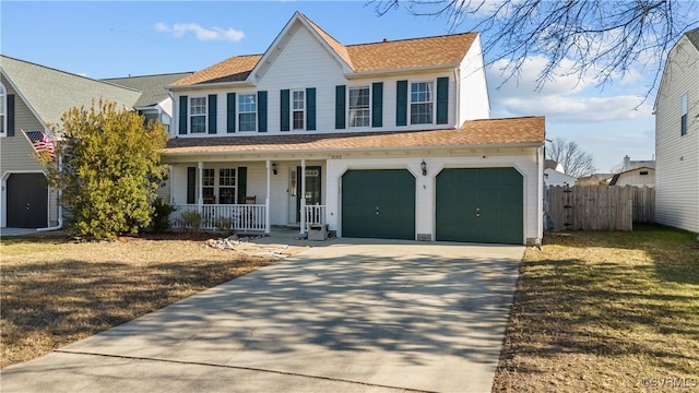 colonial home featuring a garage, a front lawn, and a porch