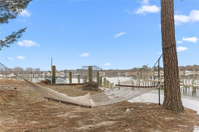 surrounding community with a dock and a water view