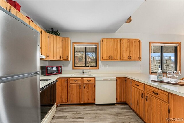 kitchen with sink, white appliances, and light wood-type flooring