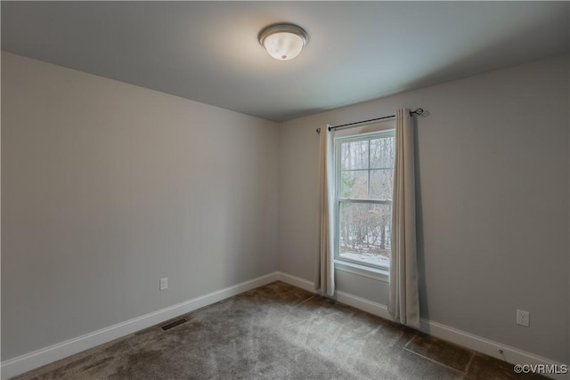 unfurnished room featuring dark colored carpet