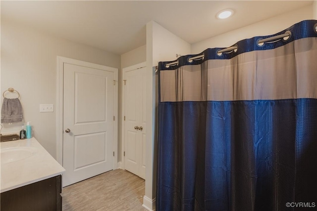 bathroom featuring wood-type flooring, vanity, and a shower with shower curtain