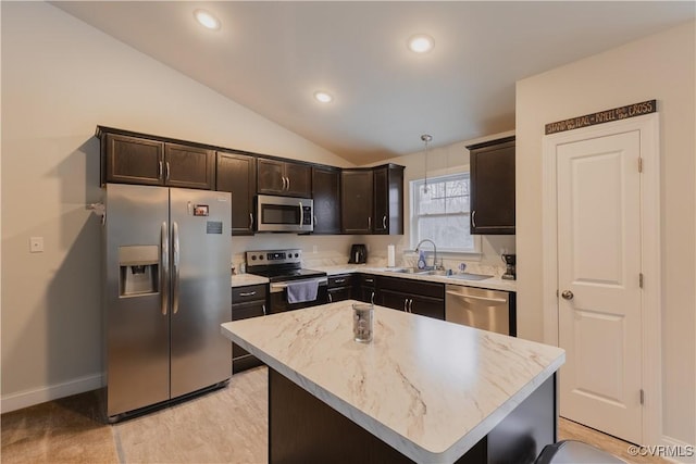 kitchen featuring vaulted ceiling, a center island, sink, hanging light fixtures, and stainless steel appliances