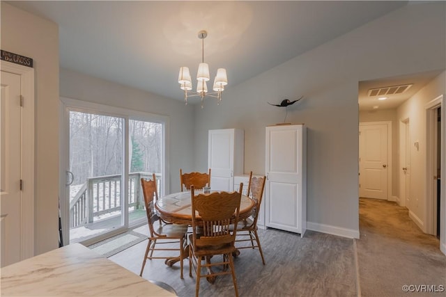 dining space featuring a notable chandelier and vaulted ceiling