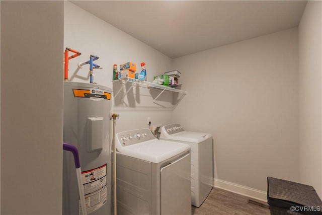 washroom with electric water heater, wood-type flooring, and separate washer and dryer