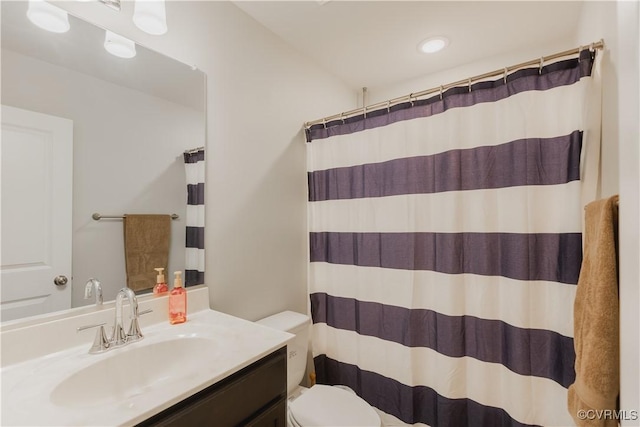 bathroom with toilet, vanity, and walk in shower