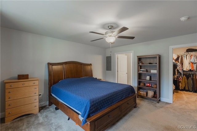 carpeted bedroom featuring ceiling fan, a walk in closet, a closet, and electric panel