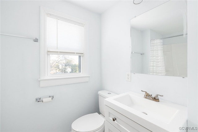 bathroom featuring a shower with curtain, vanity, and toilet