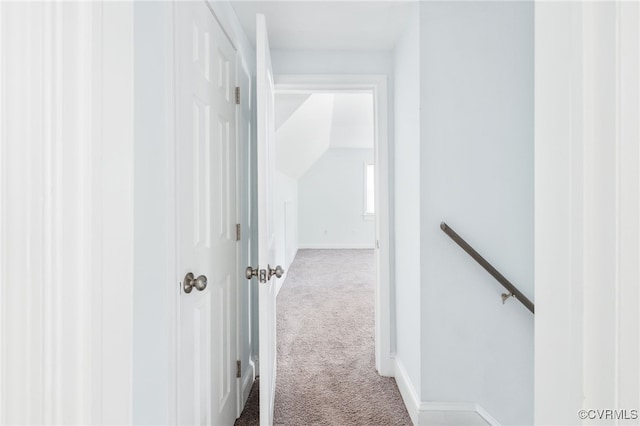 hallway featuring vaulted ceiling and carpet floors