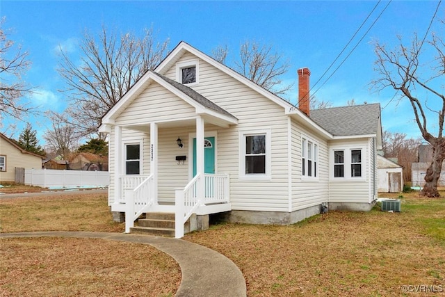 bungalow featuring a front lawn and central AC