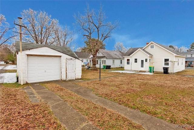 exterior space featuring an outbuilding, a front lawn, and a garage